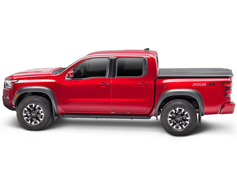 UnderCover Elite one-piece tonneau cover closed on a pickup bed, full side profile, the lid running flush along the bed rail for the whole length of the box.