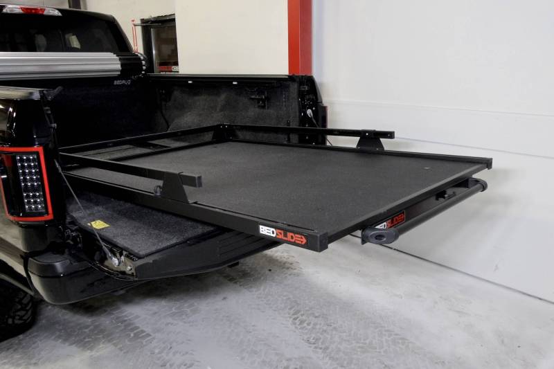 BEDSLIDE 1000 Classic cargo slide in Black Edition finish extended out over the open tailgate of a black pickup