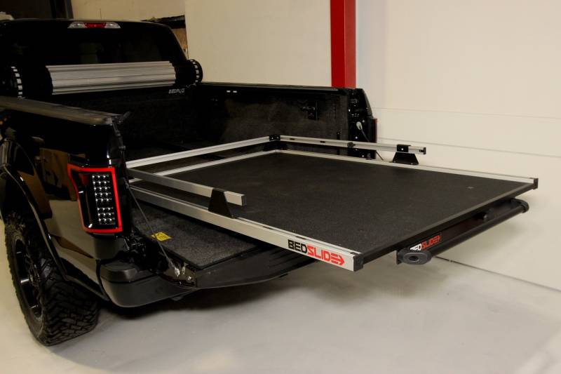 BEDSLIDE 1500 Contractor cargo slide in Silver finish extended out over the open tailgate of a black pickup