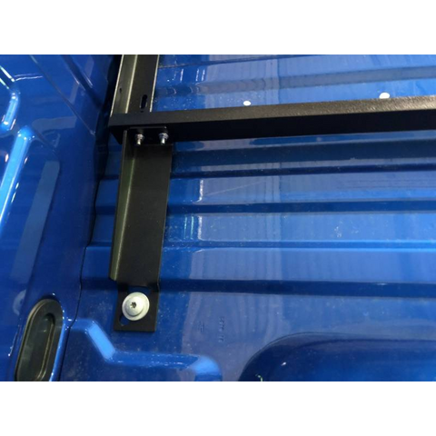 BEDSLIDE no-drill mounting bracket fitted vertically against the side wall of a blue Ford truck bed, bolted at the floor