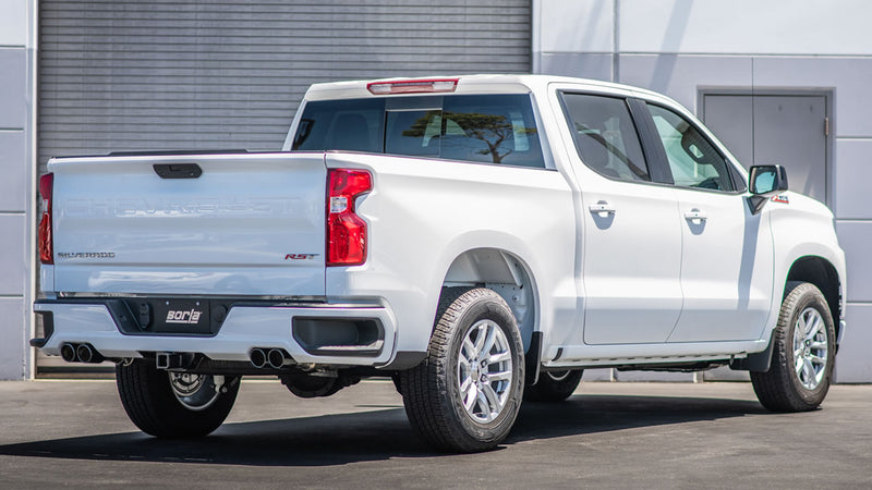 Borla ATAK Cat-Back Exhaust System installed on a Chevrolet Silverado 1500: A white Chevrolet Silverado 1500 RST seen from the rear quarter with dual exhaust tips on each side and a Borla plate