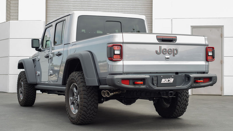 Borla ATAK Cat-Back Exhaust System installed on a Jeep Gladiator: rear three-quarter view of a silver Jeep Gladiator with a Borla dual-tip exhaust exiting near the rear bumper