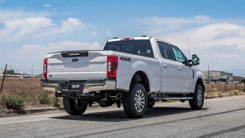 Borla ATAK Cat-Back Exhaust System installed on a Ford F-250 Super Duty: rear three-quarter view of a white Ford Super Duty pickup with a Borla exhaust tip ahead of the rear wheel