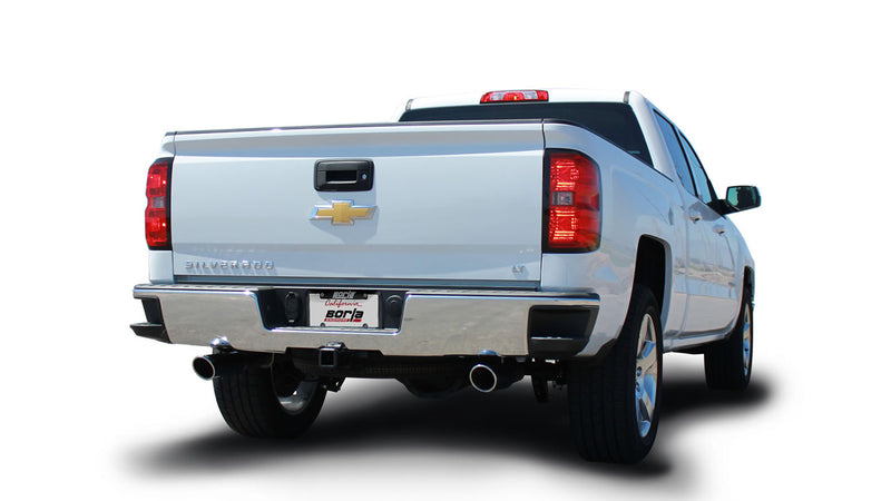 Borla ATAK Cat-Back Exhaust System installed on a Chevrolet Silverado 1500: white Chevrolet Silverado pickup seen from the rear quarter on white with split rear exhaust tips and a Borla plate