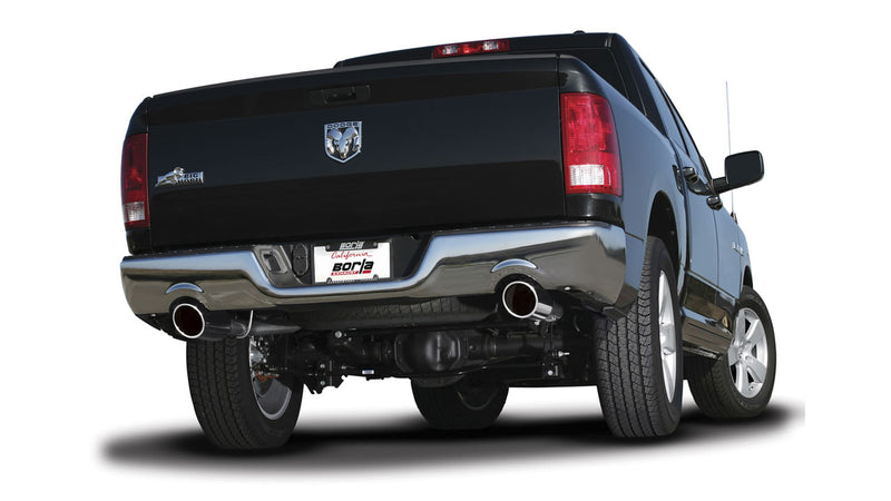 Borla Touring Cat-Back Exhaust System installed on a Ram 1500: rear three-quarter view of a black Ram 1500 on white showing dual polished exhaust tips exiting at each rear corner