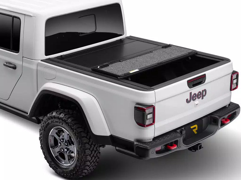 UnderCover Ultra Flex hard folding tonneau cover part-open with the rear panel folded forward over the middle panel, rear three-quarter view.