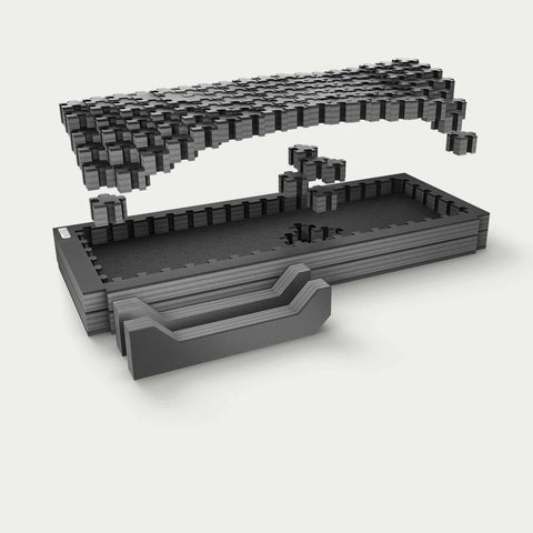Exploded studio render of the midsize short DECKED Piecekeeper PuzzleFoam showing three stacked foam layers, the pluck-grid top sheet and two stepped brace blocks