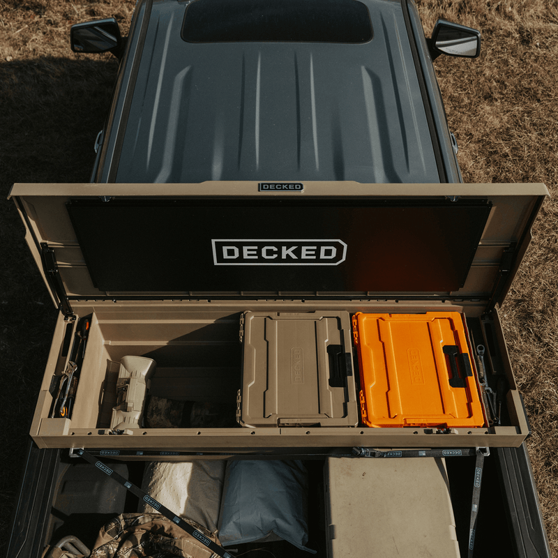Overhead view into the tub of a Fender Dirt tan DECKED Tool Box holding tan and orange DECKED cases plus hand tools