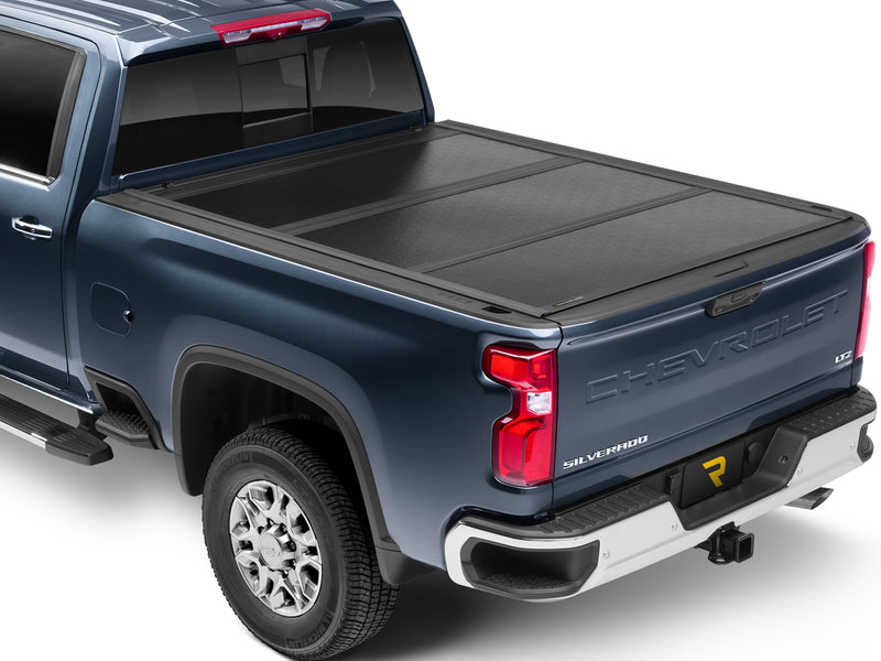 UnderCover Flex hard folding tonneau cover closed and flush across the full bed, wide rear three-quarter view showing the panel seams and low-profile rails.
