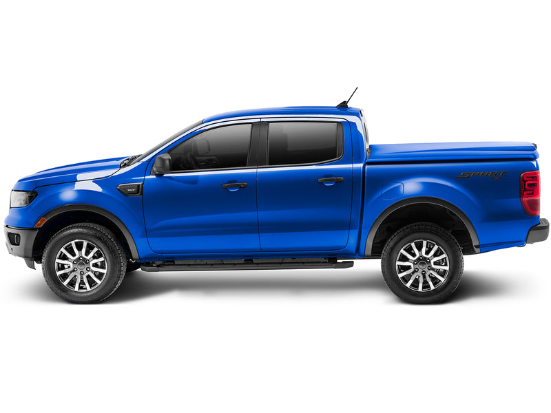 UnderCover Elite LX one-piece tonneau cover closed on a pickup bed, full side profile, the lid running flush along the bed rail for the whole length of the box.