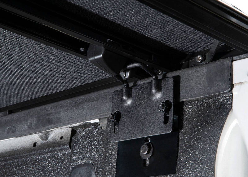 Rail clamp hooked to a bracket on the inside of the bed wall