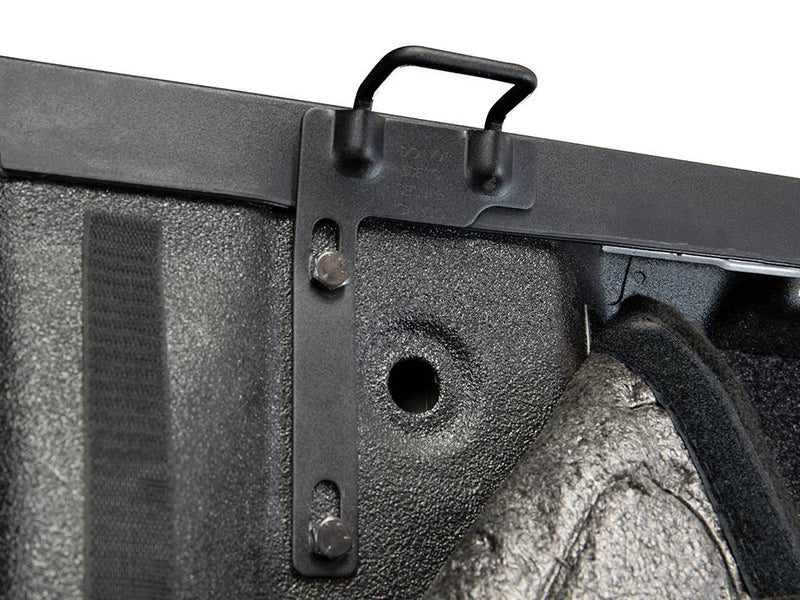 Front bracket with a steel tie-down loop bolted at the bed corner