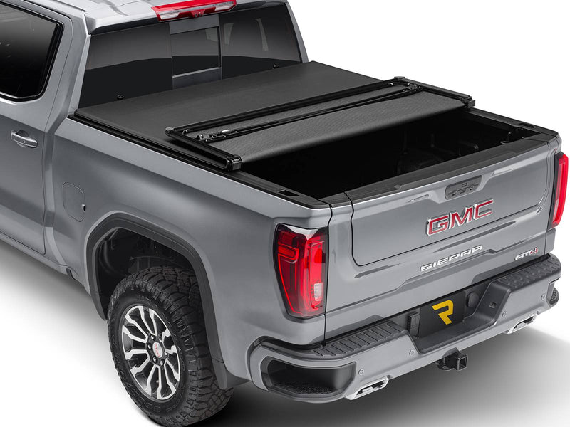 Soft folding tonneau cover with the rear section folded forward, studio rear three-quarter view