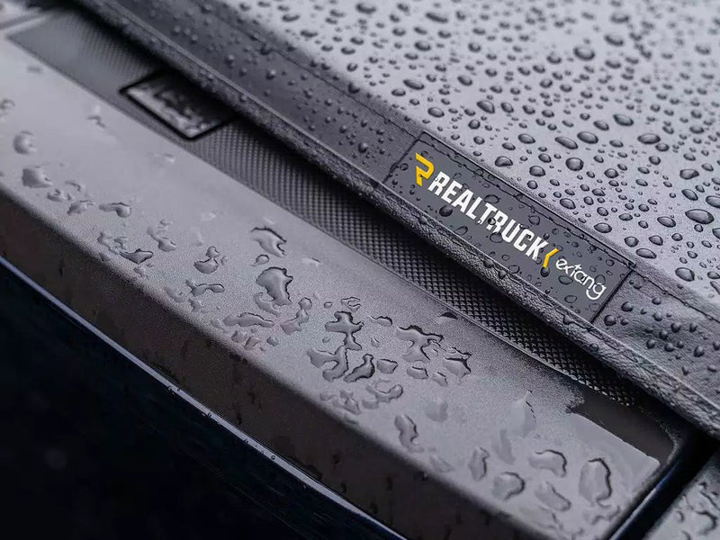 Rain beading on the vinyl cover beside its Extang logo patch
