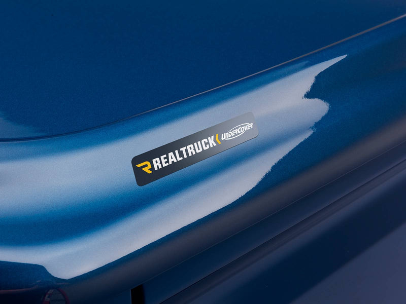 Close-up of the small gray UnderCover nameplate applied to the rear lip of the LUX lid.