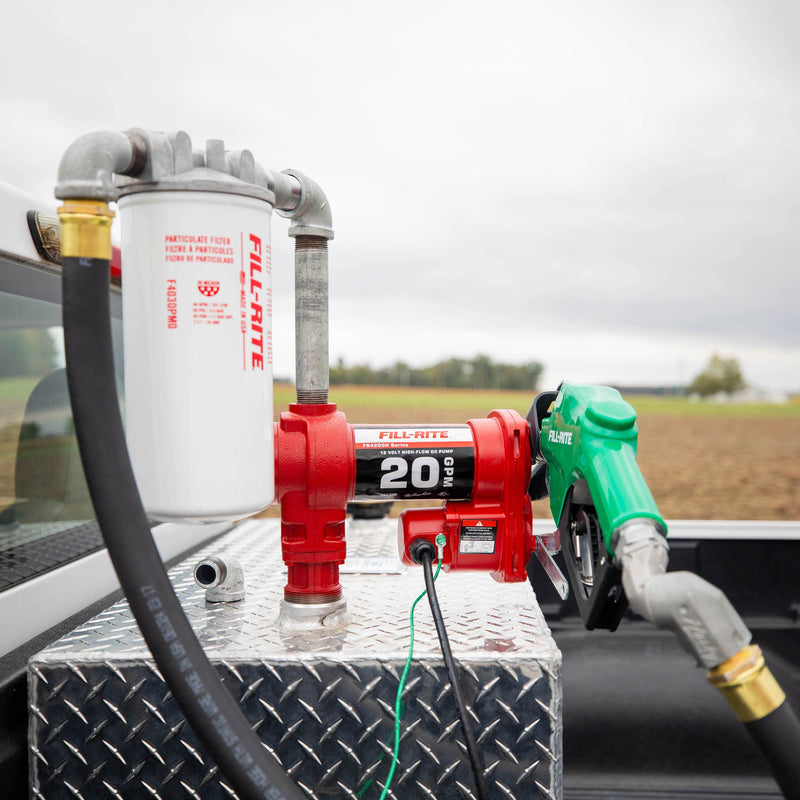 Fill-Rite FR4220HDSFQ 12V DC 20 GPM Fuel Transfer Pump with Nozzle, Filter, & Swivel, mounted on a diamond-plate transfer tank in a pickup bed