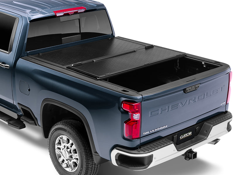 Gator EFX hard folding tonneau cover: A blue Chevrolet Silverado heavy duty with its hard folding cover partly folded