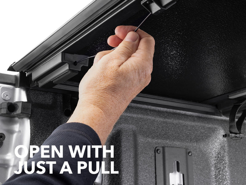 Close-up of the Gator EFX tonneau cover: A hand pulls the release cable under a hard folding cover panel
