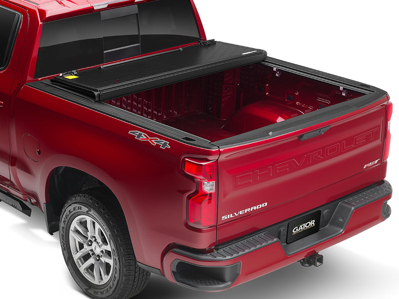 Gator EFX hard folding tonneau cover: A red Chevrolet Silverado with its hard folding cover folded toward the cab and the bed open