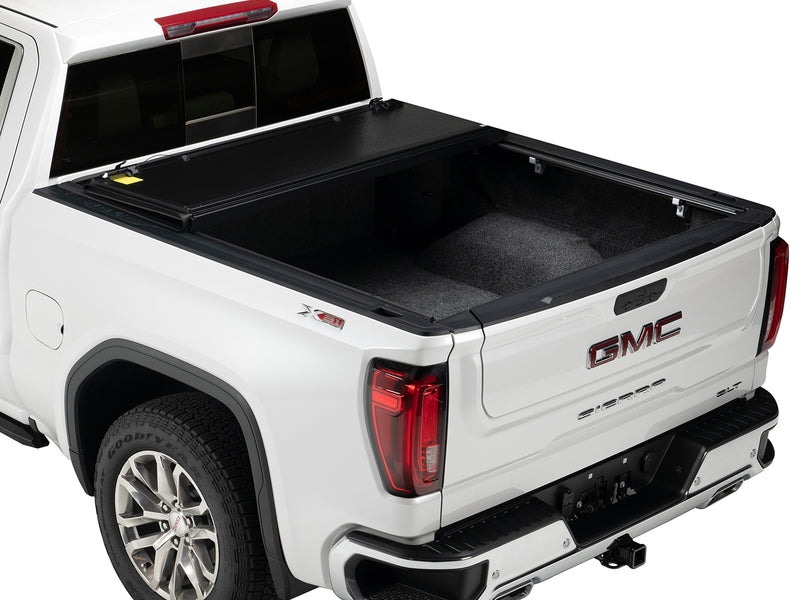 Gator EFX hard folding tonneau cover: A white GMC Sierra with its hard folding cover folded forward and the bed open