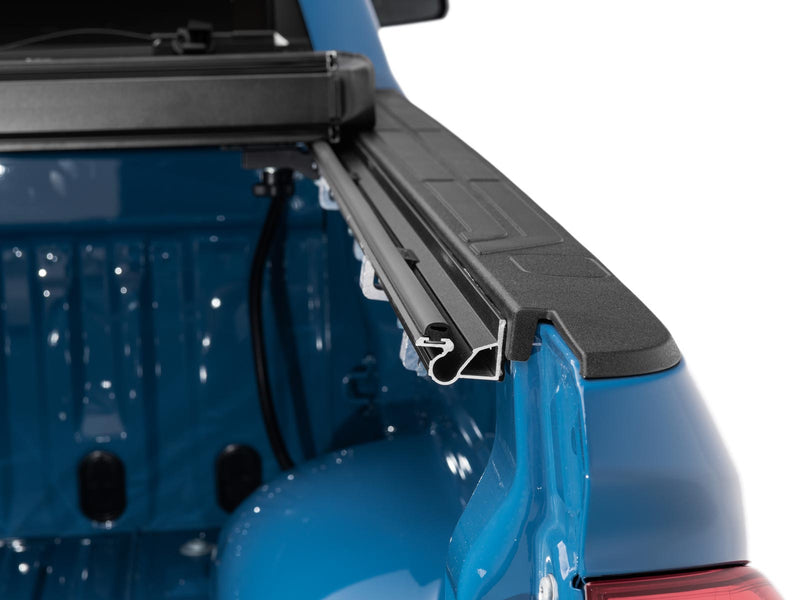 Close-up of the Gator EFX tonneau cover: close-up of the black cover rail and seal running along the bed rail at the rear corner of a blue truck bed
