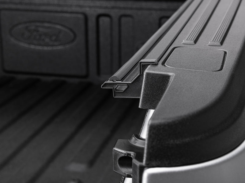 Gator EFX hard folding tonneau cover: Close-up of the cover rail and clamp at the front of a Ford bed with the Ford script stamped in the bed wall
