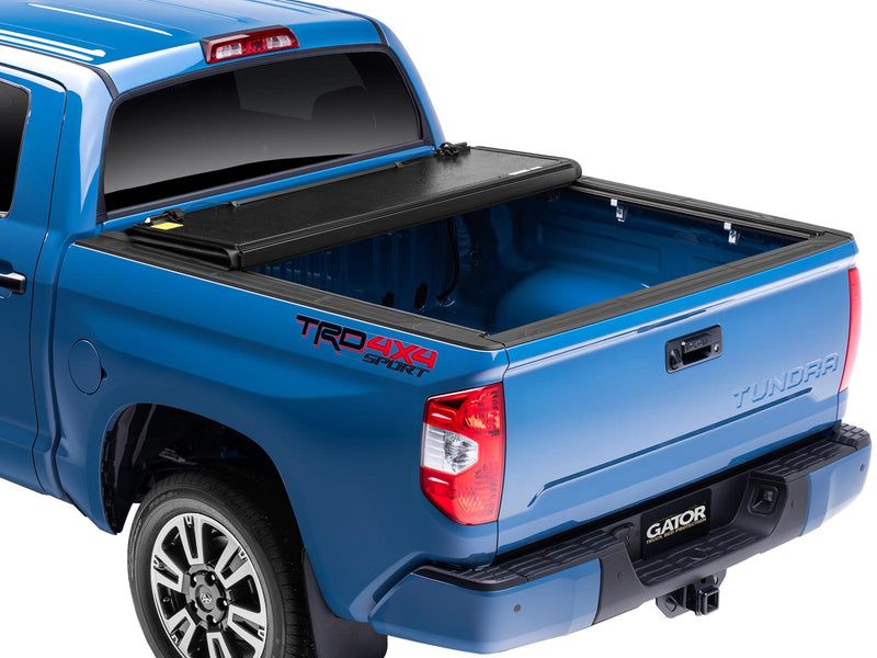 Gator EFX hard folding tonneau cover: Rear three-quarter view of a blue Toyota Tundra TRD 4x4 Sport with the hard folding cover fully folded against the cab, bed open