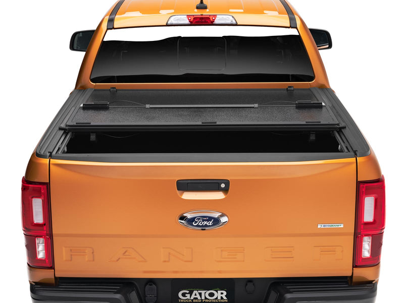 Gator EFX hard folding tonneau cover: Rear view of an orange Ford Ranger with the hard tri-fold cover folded part way
