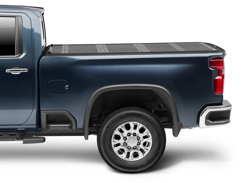 Gator FX hard folding tonneau cover: closed, side view on a blue Chevrolet heavy-duty pickup