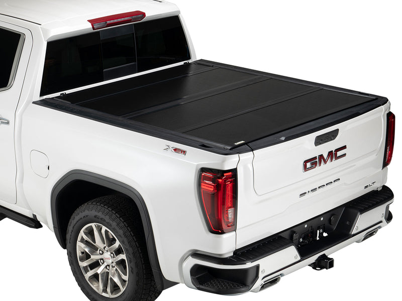 Gator FX hard folding tonneau cover: closed on a white GMC pickup, rear three-quarter view