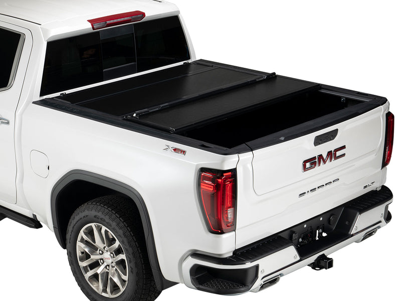 Gator FX hard folding tonneau cover: rear panel folded forward on a white GMC pickup