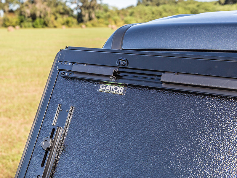 Gator FX hard folding tonneau cover: folded panels standing upright with the Gator label on the underside