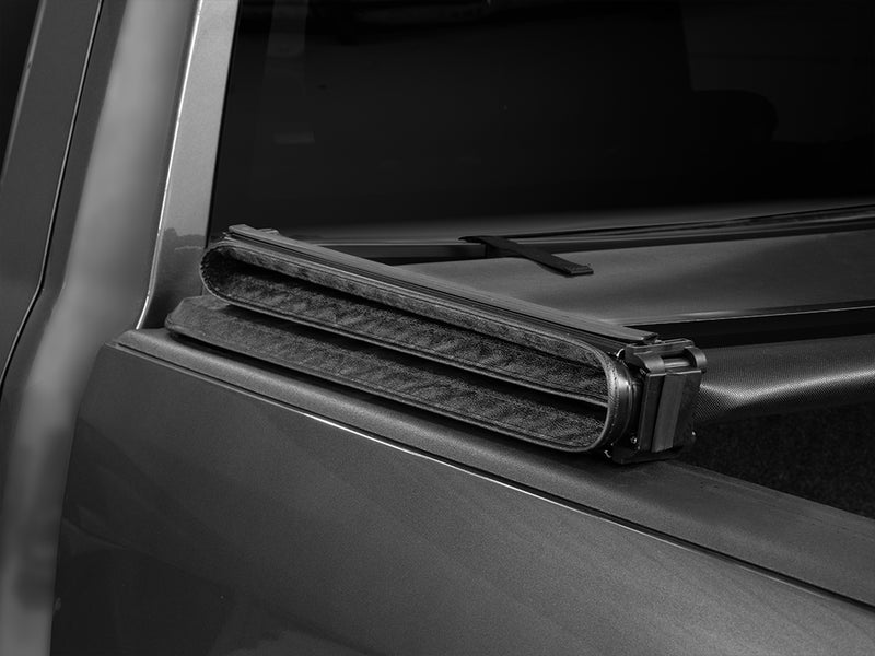 Gator SFX tonneau cover (open) on a pickup bed: folded soft cover stack resting against the front of the bed behind a gray cab