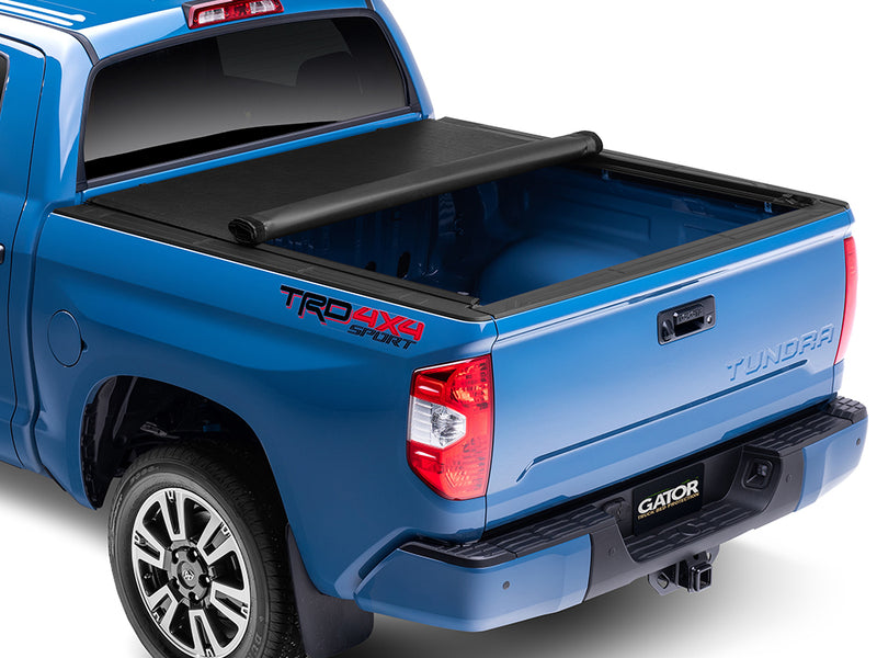 Gator SRX soft roll-up tonneau cover: Blue Toyota Tundra TRD 4x4 Sport with a soft roll-up tonneau cover partly rolled toward the cab