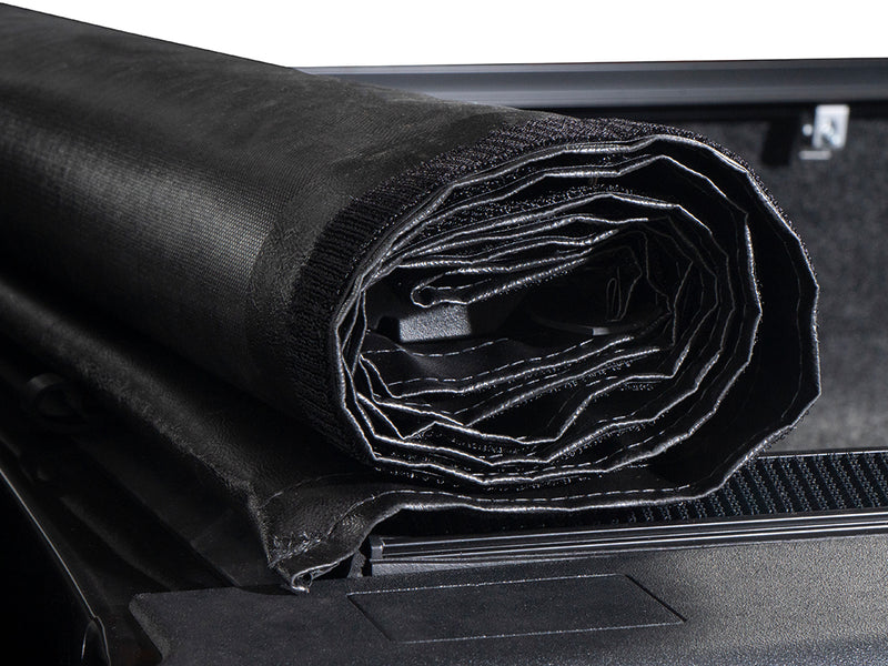 Gator SRX soft roll-up tonneau cover: Close-up of a rolled soft vinyl tonneau cover showing its layered roll at the front of the bed