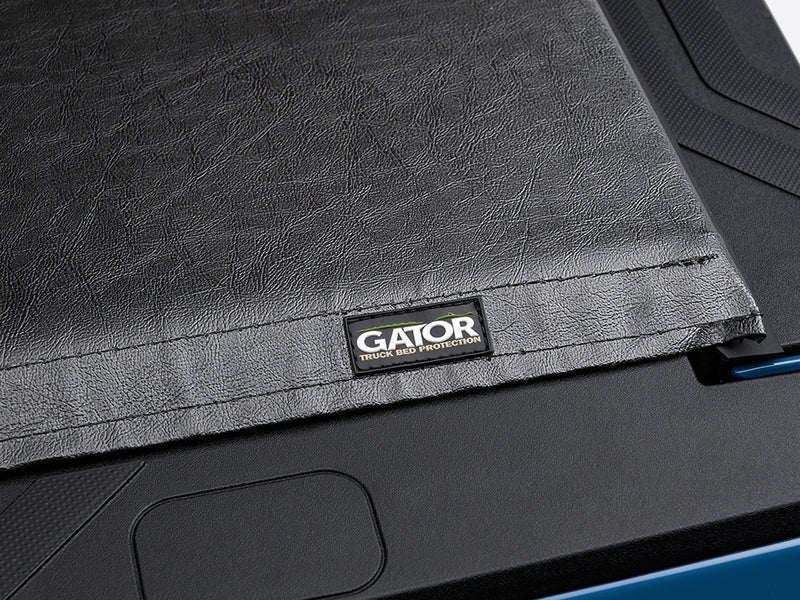 Gator SRX soft roll-up tonneau cover: Close-up of the textured black vinyl of a soft tonneau cover with a Gator logo tag at the tailgate corner