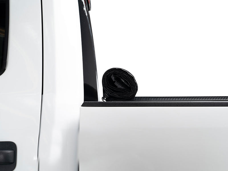 Gator SRX soft roll-up tonneau cover: Side view of a white pickup bed with the soft cover rolled up against the cab