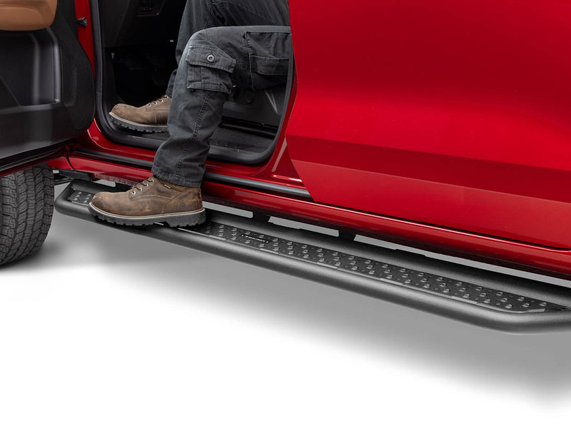 Go Rhino Dominator D6: person in cargo pants and work boots stepping onto a black side step under the open door of a red truck