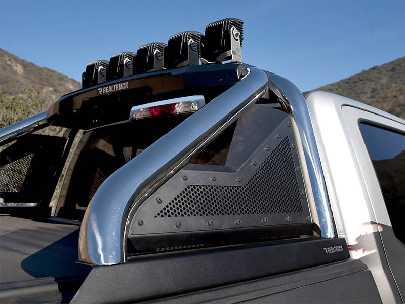 Go Rhino Sport Bar 2.0: polished stainless sport bar with black mesh panels and LED pods on a silver pickup, low angle against hills (shown with aftermarket LED light pods on the light mount, not included)