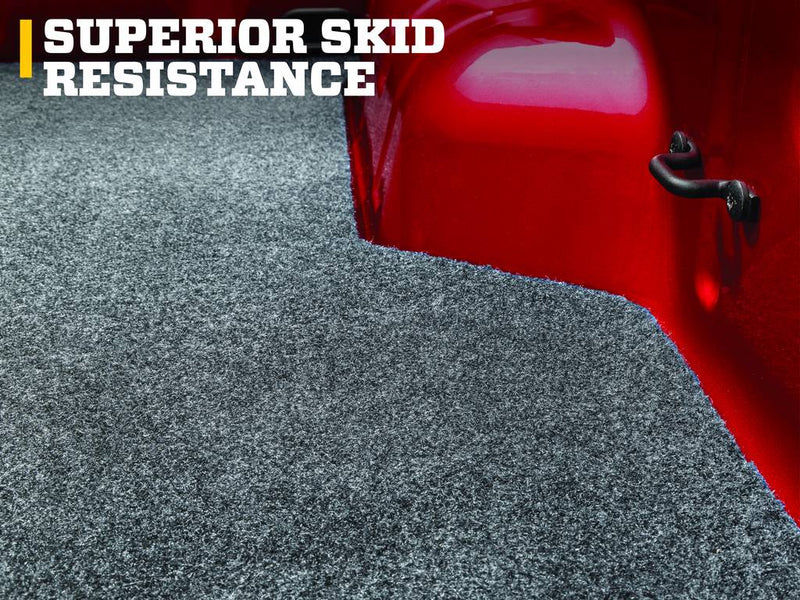 Husky Liners Guardian Comfort: gray carpet bed mat edge against a red truck-bed wall and tie-down hook