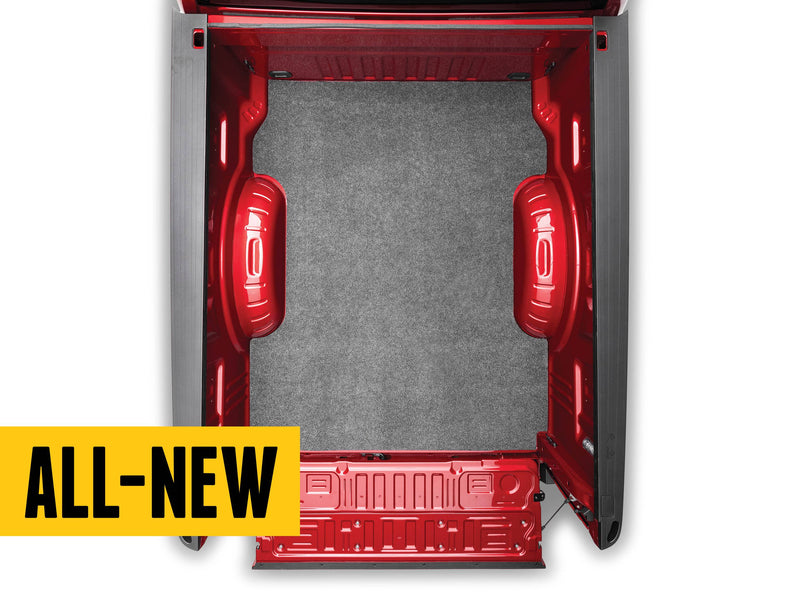 Husky Liners Guardian Comfort: top-down view of a gray carpet bed mat in a red pickup bed with the tailgate open, shown in a Ford Super Duty (likely) bed