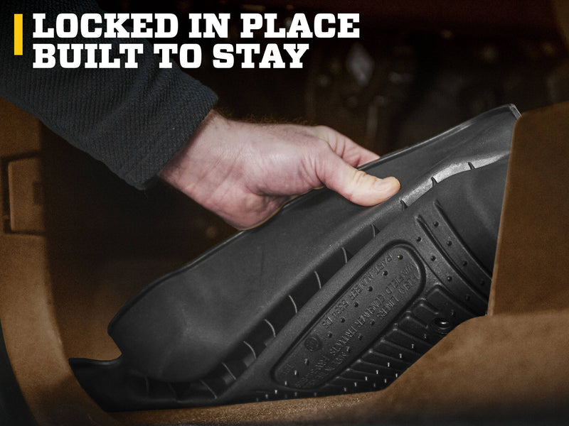 Husky Liners X-act Contour: hand lifting the edge of a black floor liner to show its cleated underside and molded label