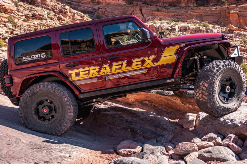 TeraFlex Trail Select Performance Kit installed on a red Jeep Wrangler JL climbing rock