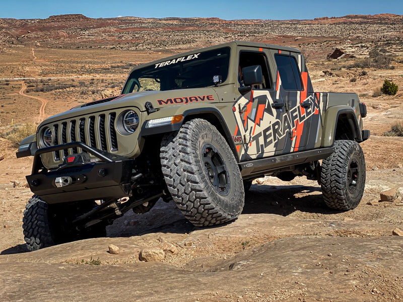 TeraFlex Trail Select Performance Kit installed on a tan Jeep Gladiator Mojave on a rocky trail