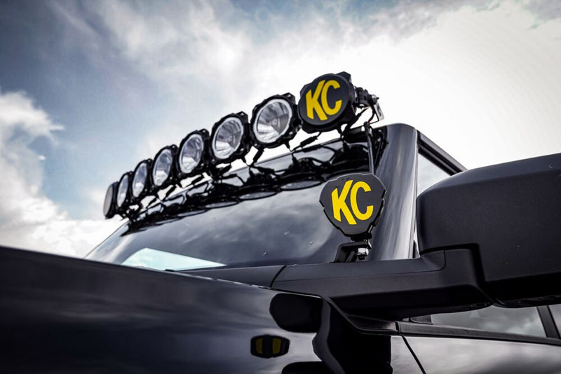 KC HiLiTES A-Pillar Ditch Light Mount Brackets on a Ford Bronco: low angle of a black Ford Bronco with a roof light bar and a ditch light by the mirror