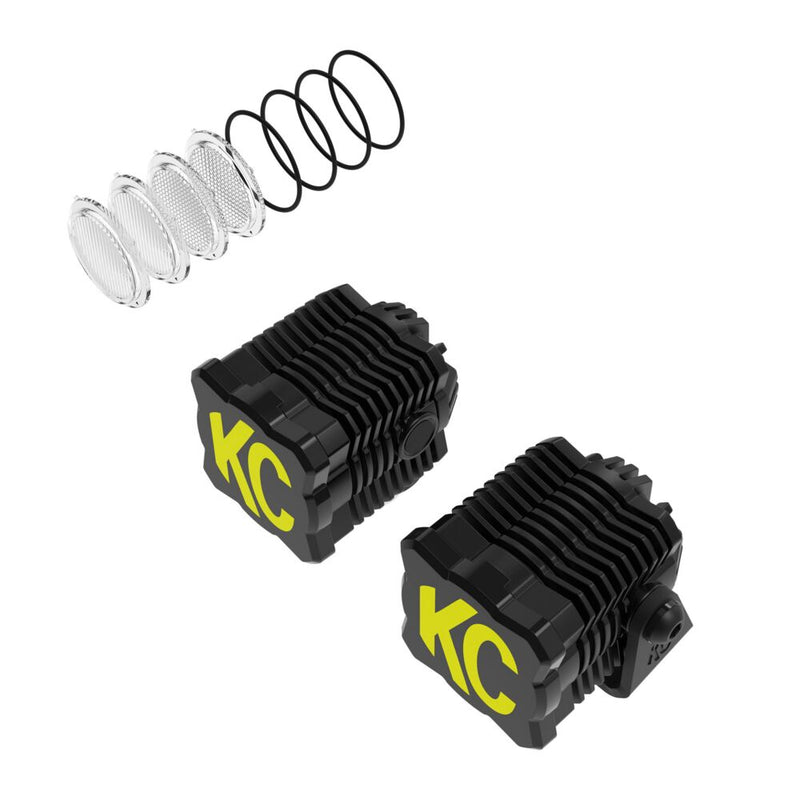 KC HiLiTES FLEX ERA 1 LED Light Pod Master Kit on a studio background: two black FLEX ERA 1 LED cube light pods with yellow and black KC covers and spare clear lenses with O-rings on a white background