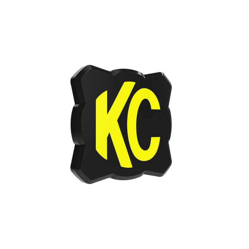 KC HiLiTES FLEX ERA 1 Light Cover & Shield on a studio background: black FLEX ERA 1 light cover with a yellow KC logo, slightly angled render on white