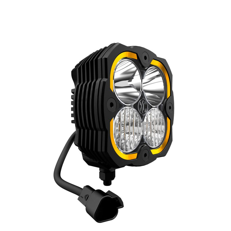 KC HiLiTES FLEX ERA 4 LED Light Pod Master Kit on a studio background: single KC FLEX ERA 4 LED light pod with an amber accent ring and a pigtail connector, front three-quarter view