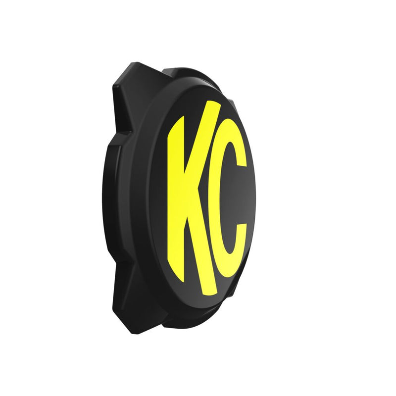 KC HiLiTES Gravity Titan & Pro6 6" Light Cover & Shield on a studio background: black 6" Pro6 light cover with a yellow KC logo at an angle