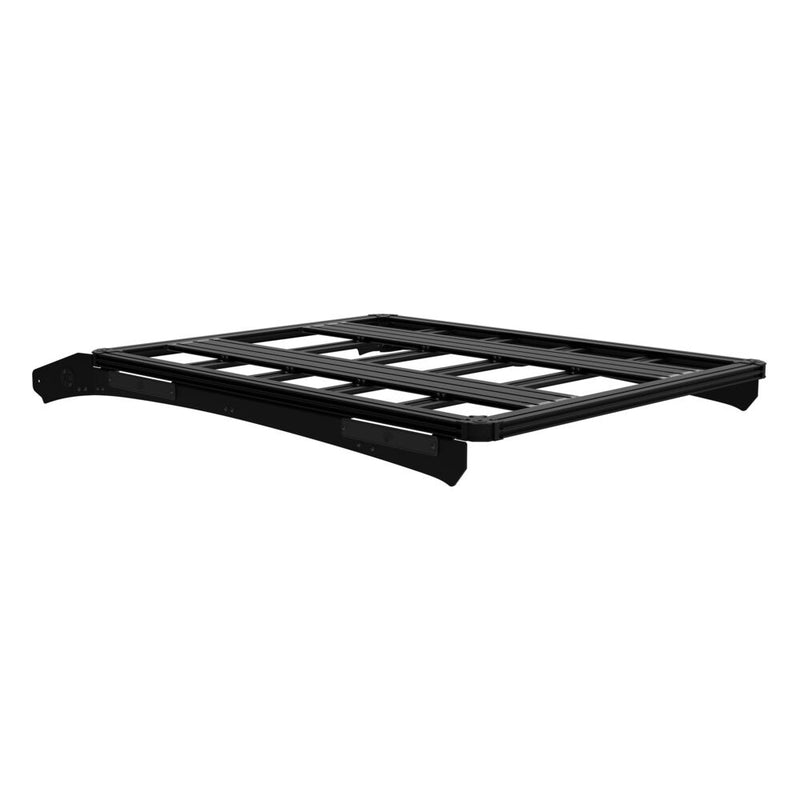 KC HiLiTES Platform One Roof Rack on a studio background: black aluminum KC Platform One roof rack with slotted crossbars and side mounting brackets, front three-quarter view on a white background